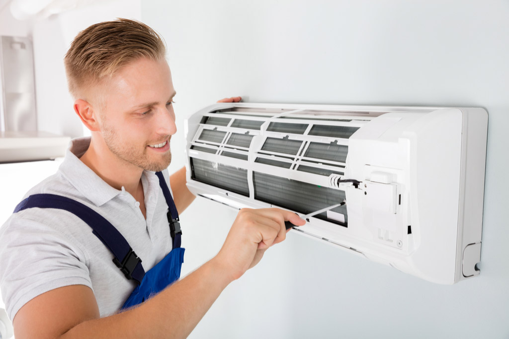 HVAC technician cleaning and repairing a ductless mini split AC in Prescott, AZ