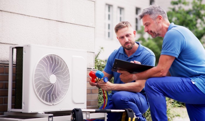 HVAC technicians reviewing an outdoor air conditioning unit in Prescott, AZ