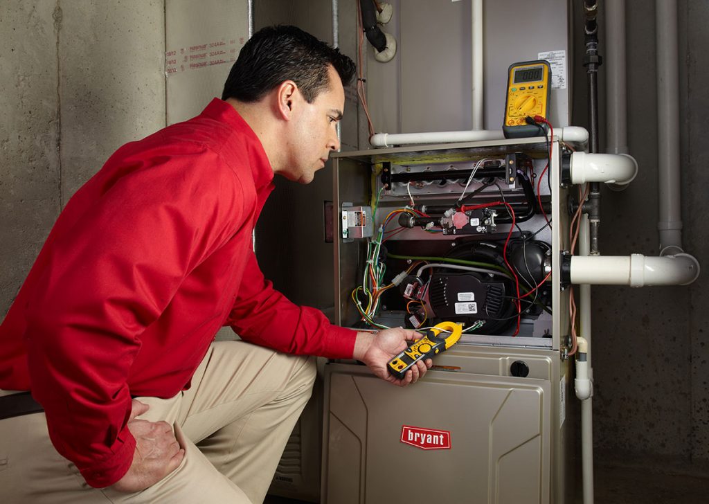 Heating and air conditioning technician servicing an indoor furnace in Prescott, AZ