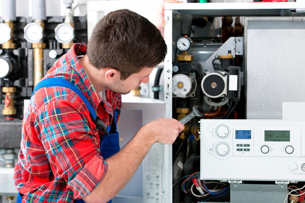 HVAC technician inspecting an indoor heating system in Prescott, AZ
