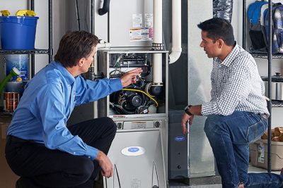 65df8c11f3e4c468cbd351a5_furnace repair vs replacement – Copy HVAC technician explaining furnace repair and maintenance to a homeowner in Prescott, AZ