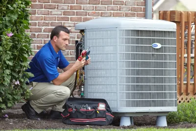 design-air-heating-and-air-conditioning-decatur-il-05 – Copy HVAC technician inspecting an outdoor air conditioning unit in Prescott, AZ