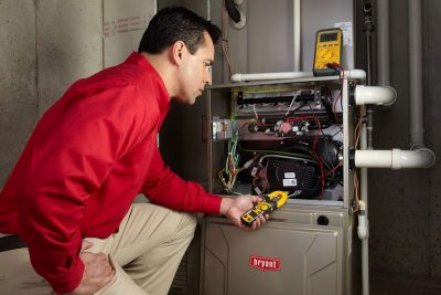 furnace repair Heating and air conditioning technician servicing an indoor furnace in Prescott, AZ